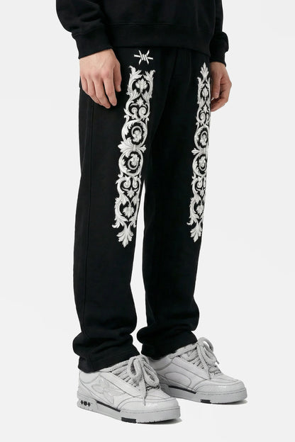 Black sweatpants with white floral patterns on a white background