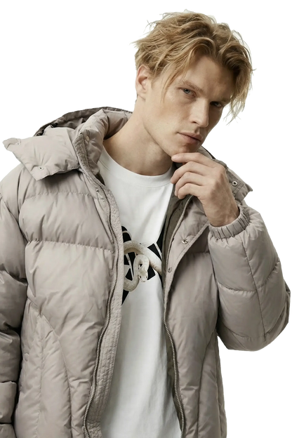 Man wearing a light gray puffer jacket over a white shirt with a black 'Ominous' logo design.