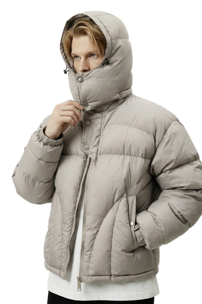 Person wearing a gray puffer jacket with a hood on a white background