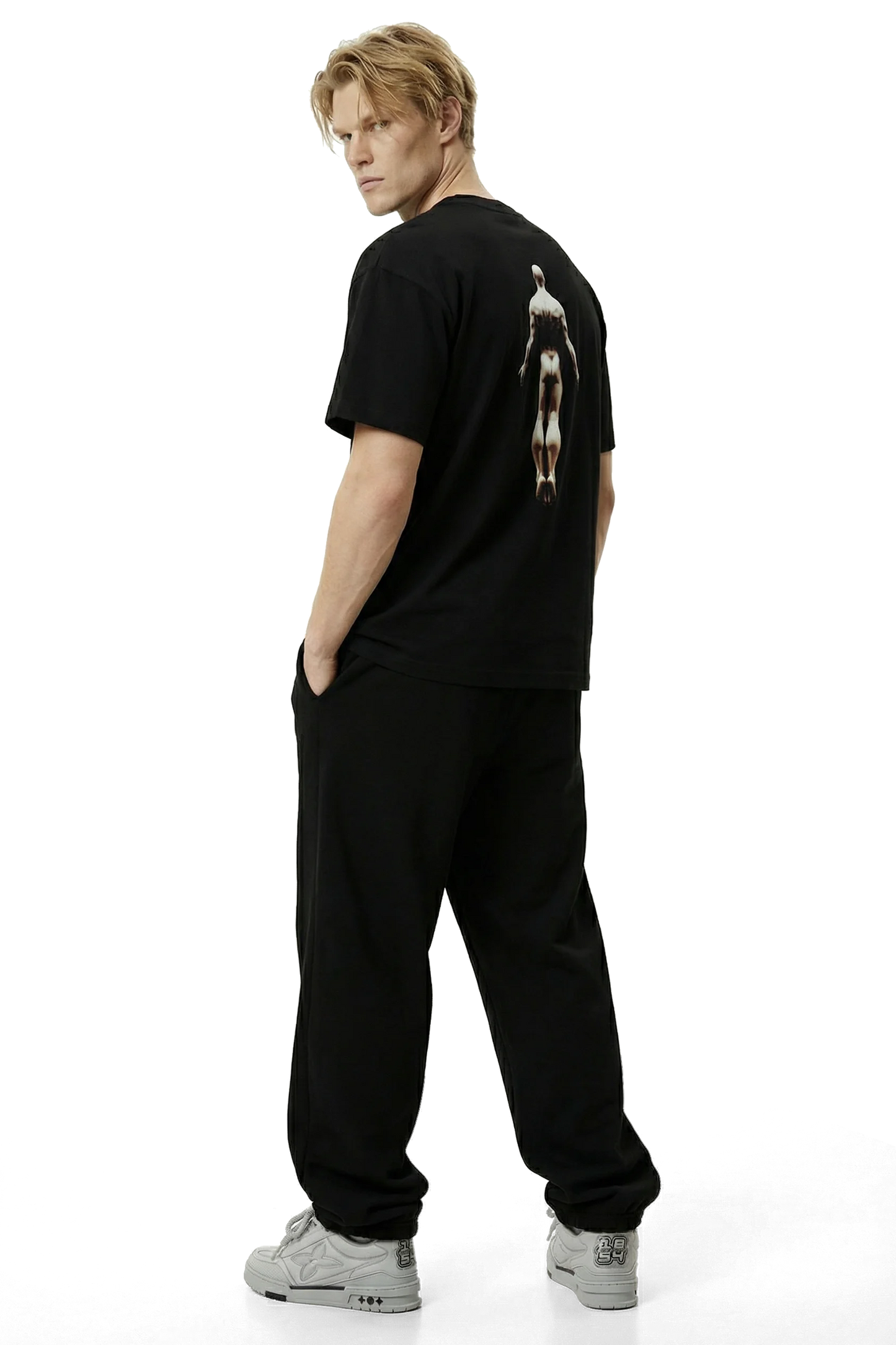 Ominous Ascendance Heavyweight Tee - Person wearing a black t-shirt with a graphic on the back and black pants on a white background