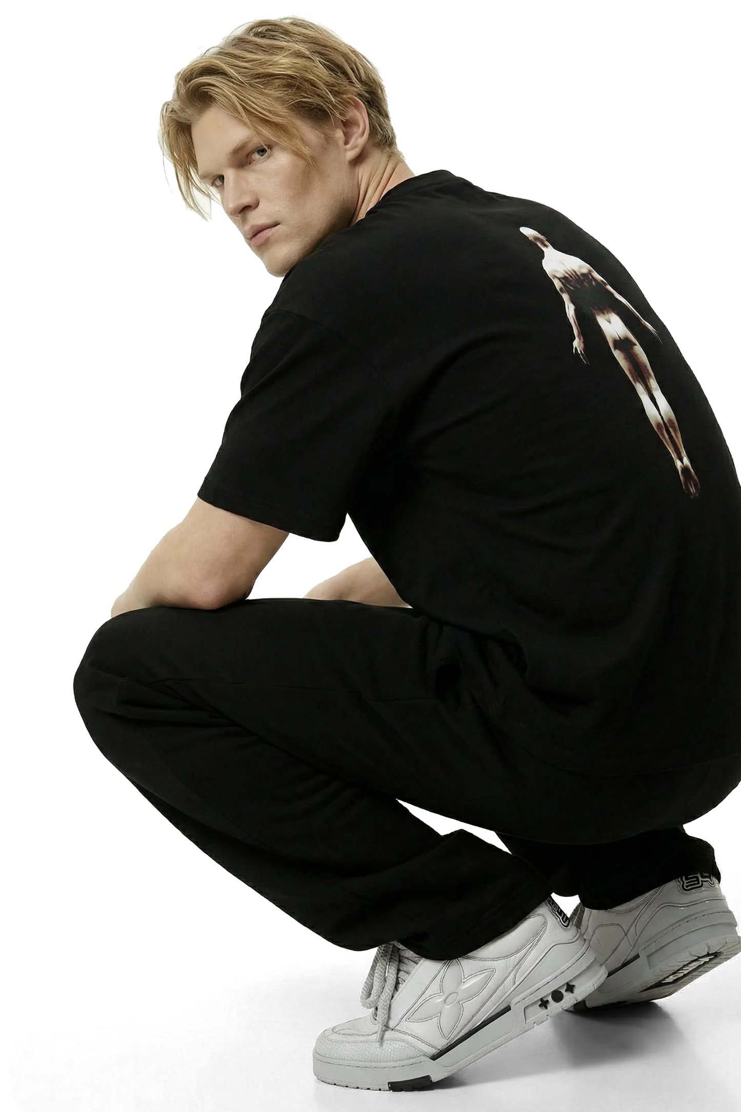 Ominous Ascendance Heavyweight Tee - Strawberry blonde hair white man wearing a black t-shirt with a floating ascending man design on the back with black sweatpants with light gray sneakers on a white background