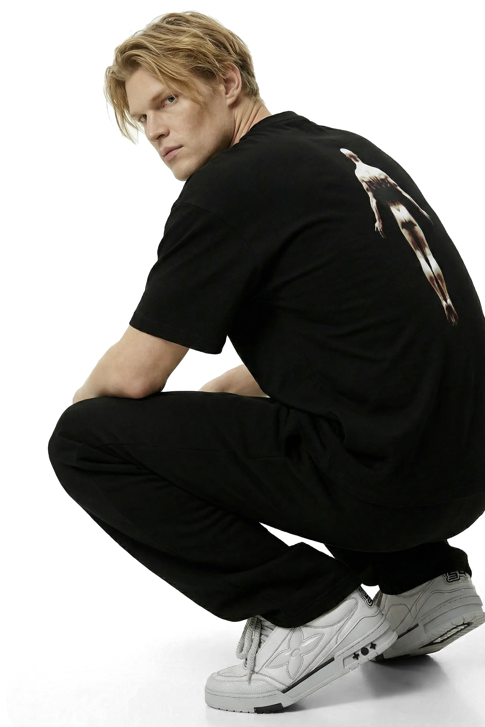 Ominous Ascendance Heavyweight Tee - Strawberry blonde hair white man wearing a black t-shirt with a floating ascending man design on the back with black sweatpants with light gray sneakers on a white background
