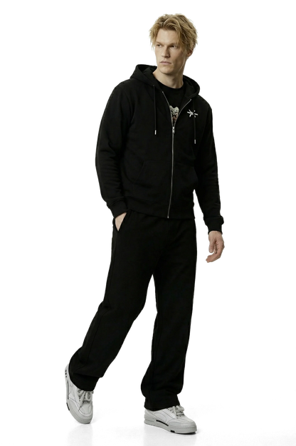 Person wearing a black hoodie and pants on a white background