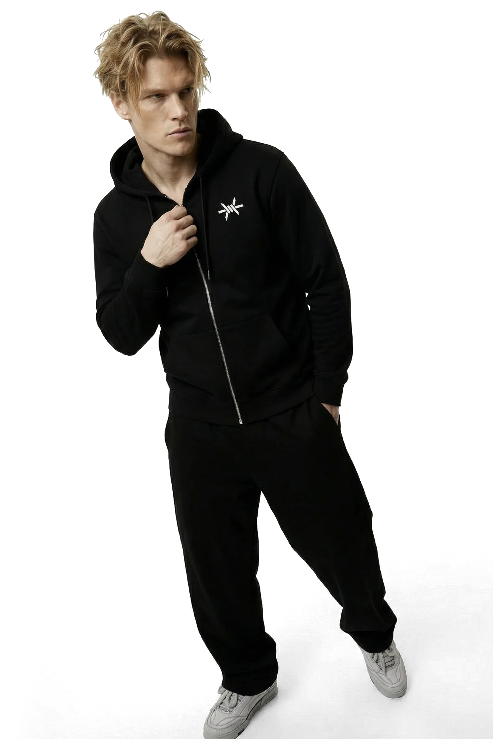 Person wearing a black tracksuit with a logo on a white background