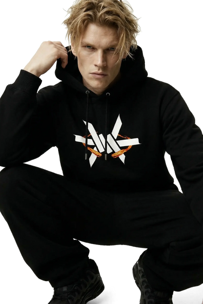Person squatting down wearing a black hoodie with a large white 'Ominous' luxury brand logo on a white background