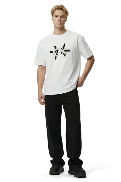 Man wearing a white t-shirt with a black 'Ominous' logo star design and black pants on a white background