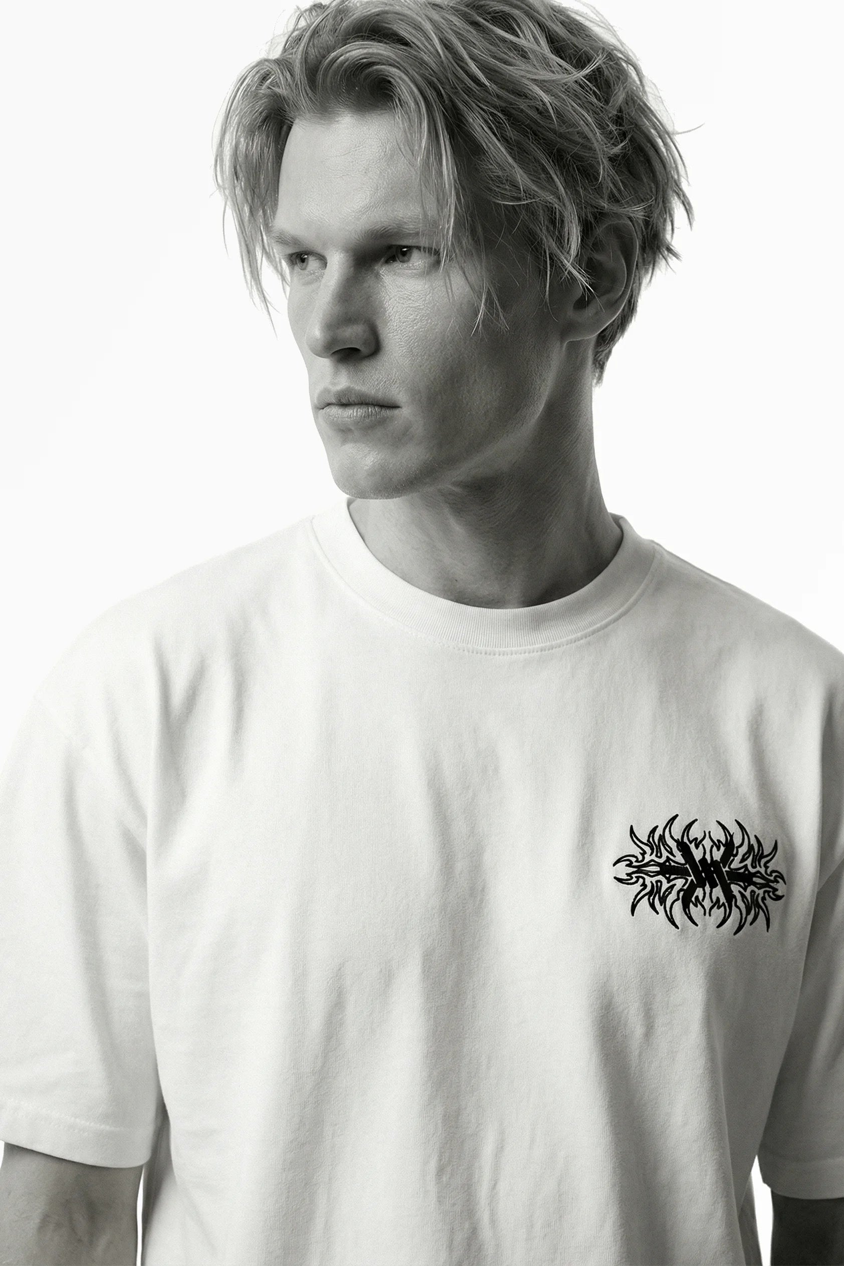 Man wearing a white t-shirt with a black graphic design on a white background