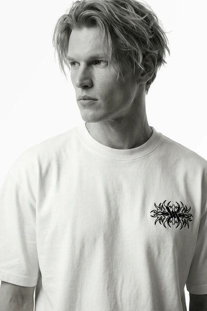 Man wearing a white t-shirt with a black graphic design on a white background