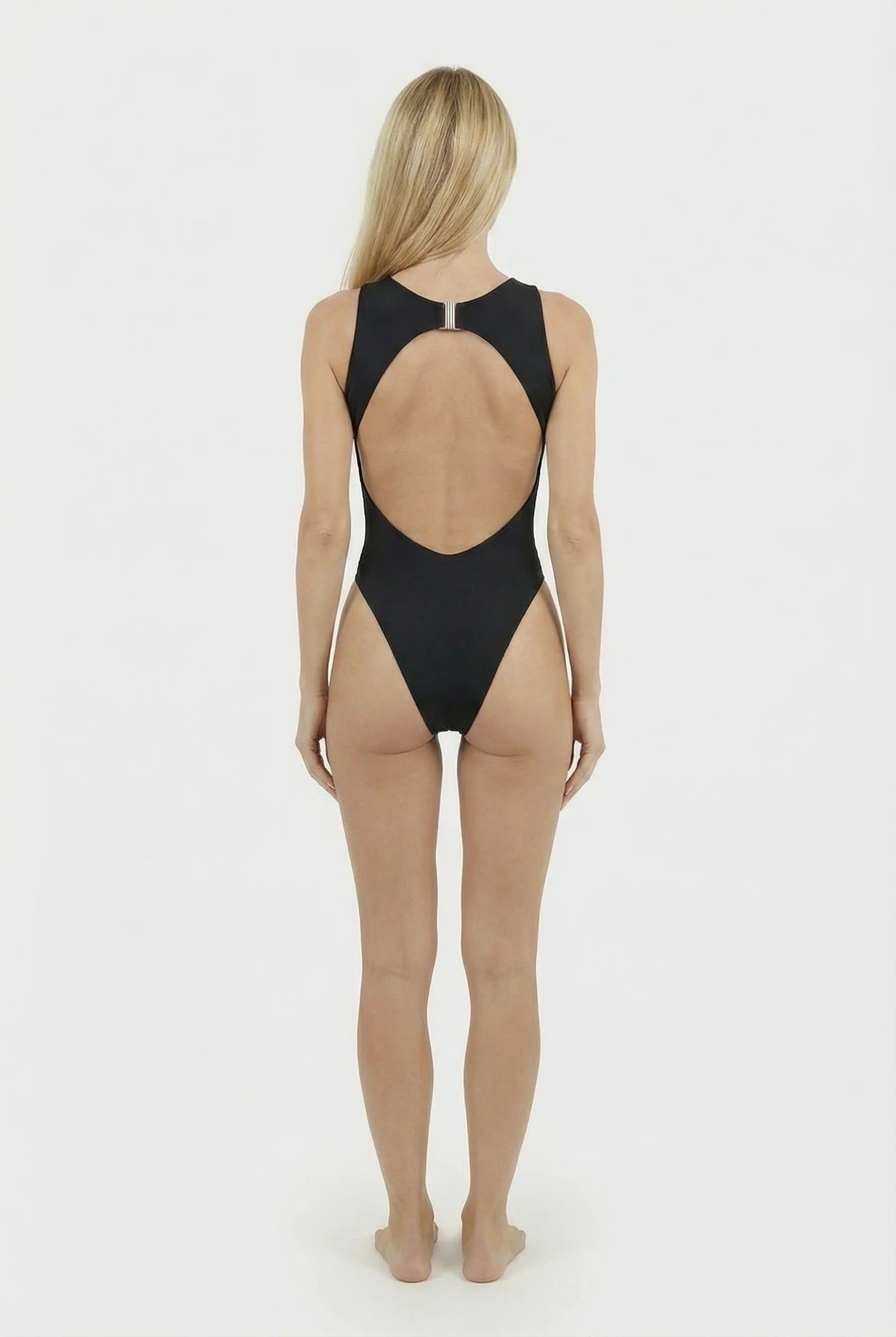Woman wearing a black swimsuit with a sheer back on a white background