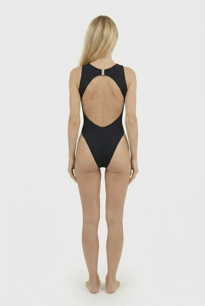 Woman wearing a black swimsuit with a sheer back on a white background