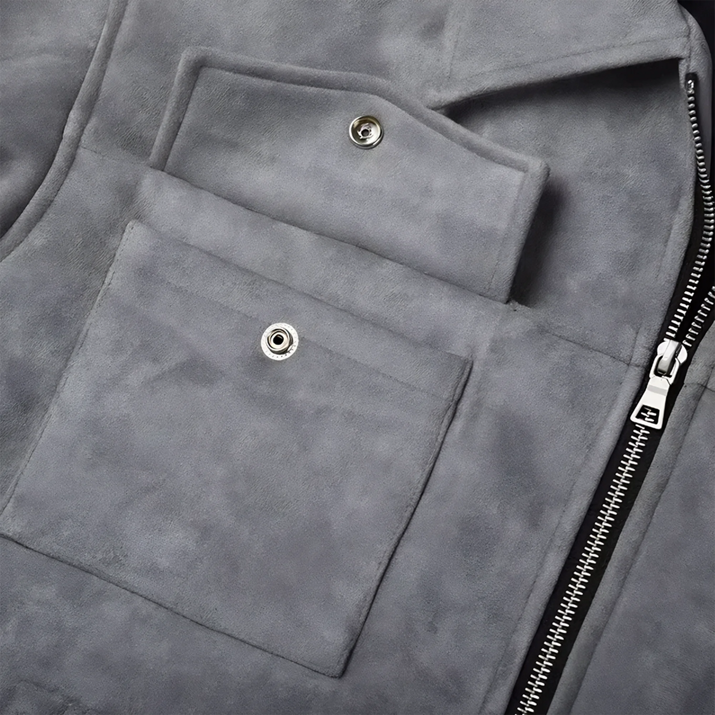 Close up of an unbuttoned button front top pocket and front metal zipper on a grey suede lounge overshirt jacket for men