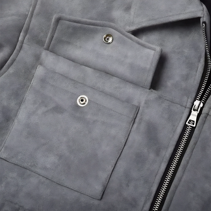 Close up of an unbuttoned button front top pocket and front metal zipper on a grey suede lounge overshirt jacket for men